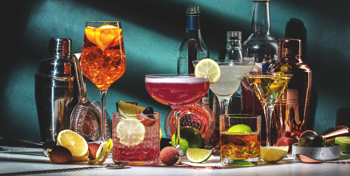 Different types of liquor on table with aqua background