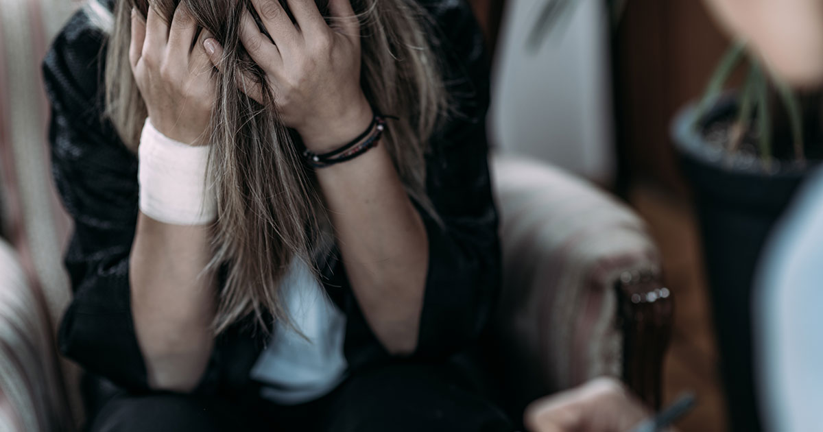 Girl with her head in her ands suffering emotional distress