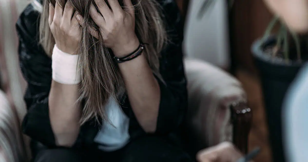 Post-Traumatic Stress Disorder Girl with her head in her ands suffering emotional distress