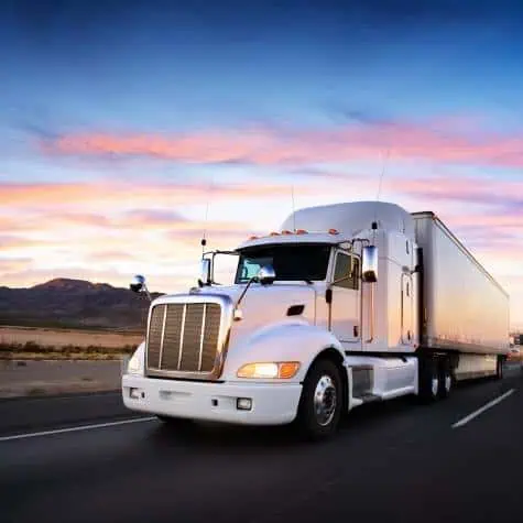 white semi truck at sunset in desert