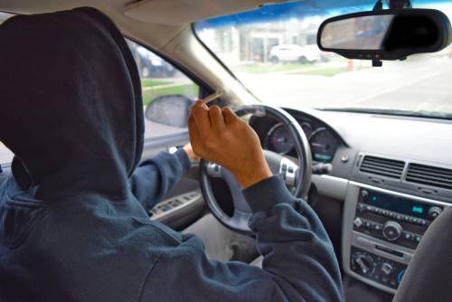 hombre conduciendo mientras fuma marihuana