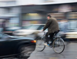 man on bicycle about to be hit by car