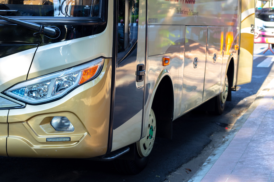 Autobús chárter de color dorado en la acera