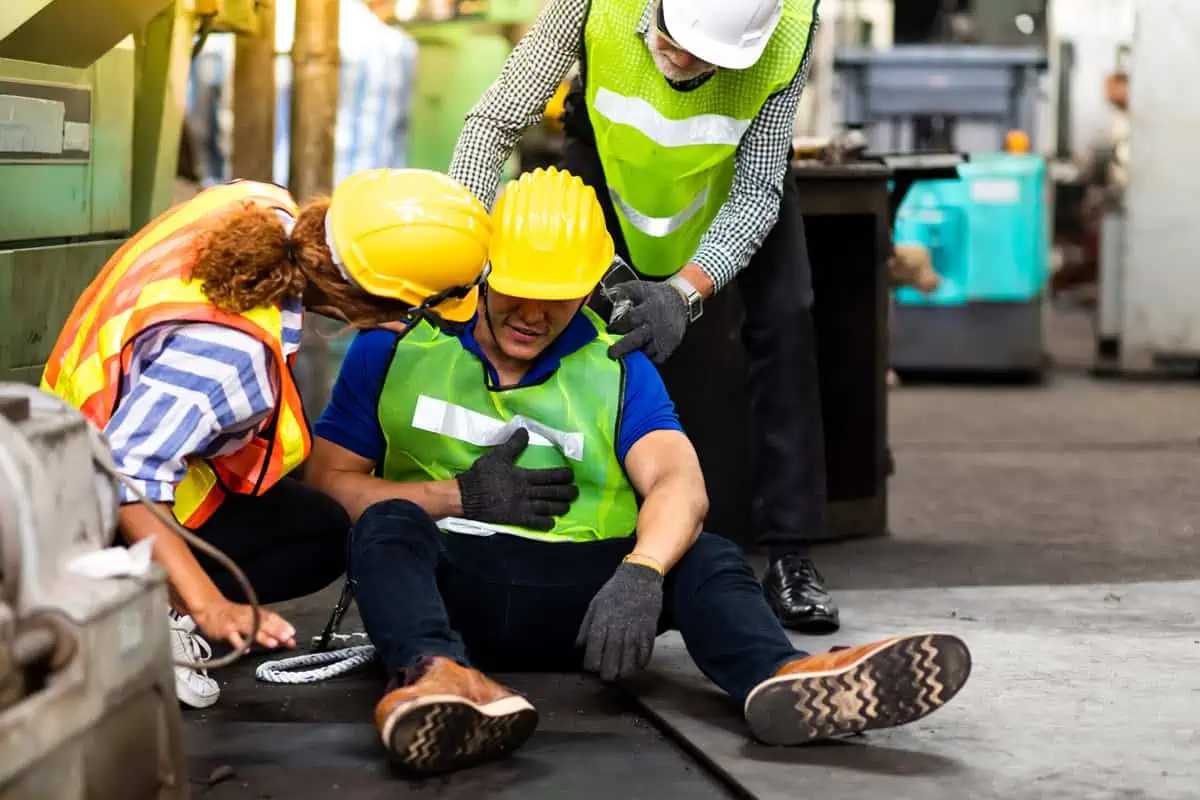 Workplace Accidents worker on floor after suffering and injury surrounded by other employees