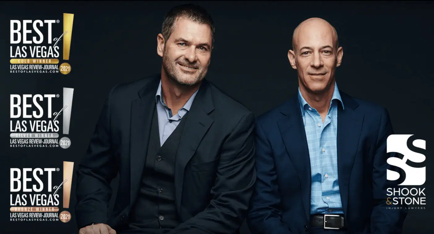 Two men in suits are seated side by side, with "Best of Las Vegas" awards and the Shook & Stone injury lawyers logo displayed to the left and bottom right of the image.