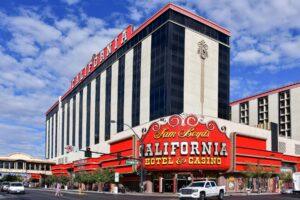 Exterior view of Sam Boyd's California Hotel & Casino in Las Vegas, featuring a large red, black, and white facade with signage and cars on the street in front.